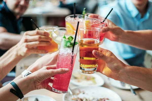 Um grupo de pessoas se saudando com seus drinks.